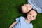 Portrait of cute twin brothers on green grass, top view