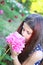 Portrait of a cute young teen girl with a peony close to her face