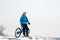 Portrait of Cyclist in Blue Resting with Mountain Bike on Rocky Winter Hill. Extreme Sport and Enduro Biking Concept.