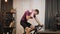 Portrait of cyclist wiping face with towel during cardio training on stationary bicycle. Man is cycling on indoor bike smart train