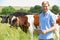Portrait Of Dairy Farmer With Digital Tablet In Field