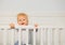 Portrait of a dancing toddler boy in the baby crib