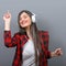 Portrait of dancing urban woman with headphones against gray background