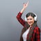 Portrait of dancing urban woman with headphones against gray background