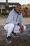 Portrait of a dark-skinned man in his 40s squatting on an outdoor tourist beach. Perhaps he works as a lifeguard or guide for tour