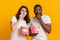 Portrait of dazed interracial couple eating popcorn with scared face expression