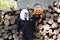 Portrait of dead bride, who is standing near the sawn logs. Next to the carved pumpkin for Halloween