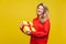 Portrait of delighted beautiful blonde woman with red listick in bright casual sweater, isolated on yellow background