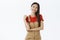 Portrait of delighted charismatic and outgoing asian woman with dark hair in cute brown overalls touching shoulder while