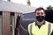 Portrait Of Delivery Driver Wearing Mask Next To Van Outside House