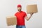 Portrait delivery man in cap with red t-shirt working as courier or dealer holding two empty cardboard boxes. Receiving