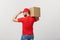 Portrait delivery man in cap with red t-shirt working as courier or dealer holding two empty cardboard boxes. Receiving