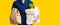 Portrait of delivery man carrying paper bag with food products  over yellow background