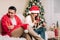 Portrait of depressed couple man and woman using cell phone during Christmas party. Tired wife and husband having a