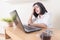 Portrait of depressed female entrepreneur sitting in front of the computer while working in the office. Young exhausted