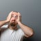 Portrait of a desperate man in shock against gray background