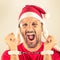 Portrait of a desperate young man with Santa Claus red hat