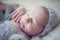 Portrait detail newborn sleeping baby on gray furry rabbit blanket with knitted woolen cap and with knitted wooll toy.