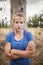 Portrait of determined woman standing with arms crossed during obstacle course