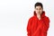 Portrait of devious good-looking asian man in red hoodie, keep secret, squinting mysterious and shush, make hush gesture