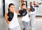 Portrait of diligent females and males training in boxing gloves