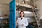 Portrait of diligent smiling female posing with olive oil containers