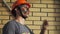 Portrait Dirty Building Worker on Background Brick Wall. Handsome Caucasian Serious Man in a Hard Hat. People Working Equipment