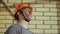 Portrait Dirty Building Worker on Background Brick Wall. Handsome Caucasian Serious Man in a Hard Hat. People Working Equipment