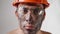 Portrait dirty tired male builder in work helmet and glasses looks camera