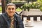 Portrait of disabled man with cerebral palsy sitting at outdoor cafe with a of coffee.