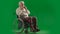 Portrait of disabled man isolated on chroma key green screen full shot. Senior bearded man sitting in wheelchair holding