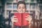 Portrait of disabled schoolboy holding book in library