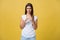 Portrait disappointed awkward attractive woman in white shirt, raising hand and shaping small item, looking at fingers