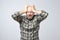 Portrait of disappointed, upset man with stubble cover face with palm, isolated on grey background.