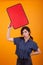 Portrait of discontent young woman holding an empty thought bubble in studio over yellow background