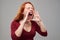 Portrait of disparate redhead woman loudly screaming