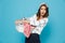 Portrait of displeased brunette woman 20s carrying laundry basket with dirty clothing, isolated over blue background