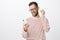 Portrait of displeased frustrated european guy in striped pullover and glasses, taking off wireless earphone and