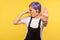 Portrait of displeased hipster girl pinching her nose and showing stop gesture. yellow background, studio shot