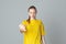 Portrait of displeased teen girl gestures by hand isolated on light grey background, wearing in casual blank yellow t shirt. Stop