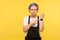 Portrait of dissatisfied angry hipster girl pointing watch on her wrist and looking impatient. yellow background, studio shot