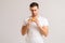 Portrait of dissatisfied young man with disgust eating bad burger on white isolated background.