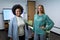 Portrait of diverse female business colleagues in meeting room looking to camera and smiling