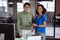 Portrait of diverse male and female colleague holding tablet and smiling standing in office