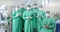 Portrait of diverse surgeons wearing surgical gowns in operating theatre, slow motion