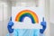 Portrait of a doctor in a mask, on which a rainbow is drawn as a sign of hope of victory over a coronovirus infection