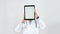 Portrait of a doctor in medical uniform holding blank digital tablet in front of his face while standing against grey