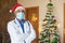 Portrait of doctor wearing mask and christmas hat celebration during covid-19 pandemic, lockdown, new normal. healthcare and