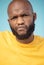 Portrait, doubt and expression with a black man in studio on a blue background feeling annoyed or frustrated. Face