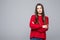 Portrait of doubting displeased popular european woman in red loose sweater and careless expression, being disappointed or